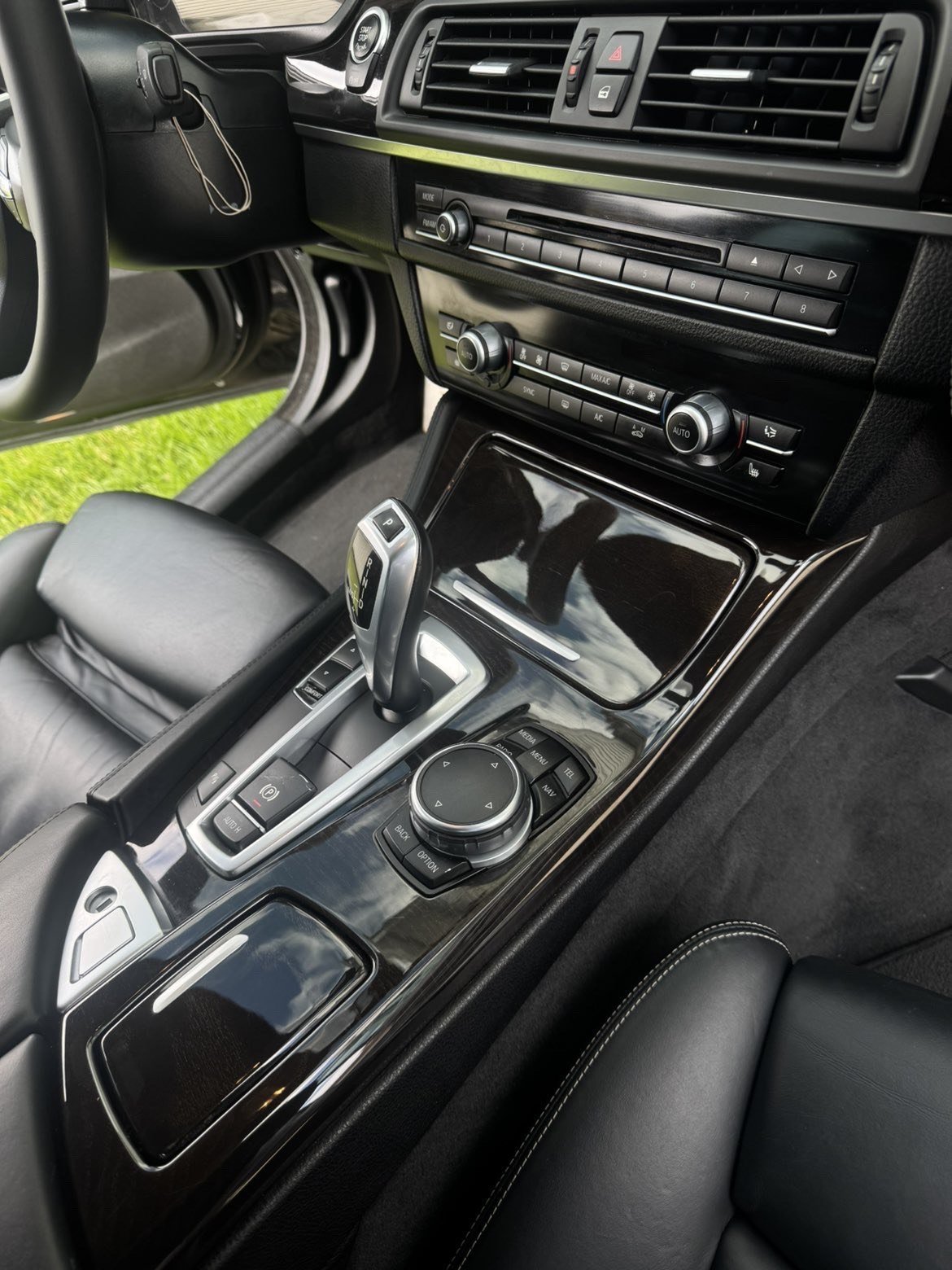 After: spotless dashboard and center console with a deep glossy black finish, completely dust-free